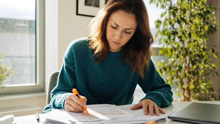A writer annotating printed pages at her desk while planning content optimization